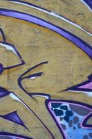 Fragment of graffiti drawings. The old wall decorated with paint stains in the style of street art culture. Colored background texture in purple tones photo