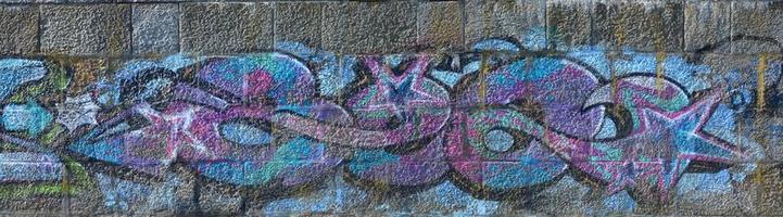 fragmento de dibujos de graffiti. la antigua muralla decorada con manchas de pintura al estilo de la cultura del arte callejero. textura de fondo coloreada en tonos fríos foto