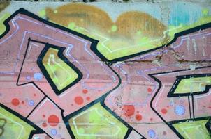 Fragment of graffiti drawings. The old wall decorated with paint stains in the style of street art culture. Colored background texture in warm tones photo