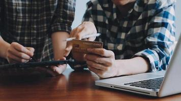 mãos segurando um cartão de crédito e usando o laptop. compras online video