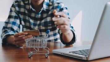 mãos segurando um cartão de crédito e usando o laptop. compras online video