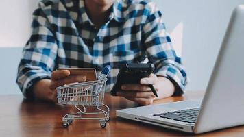 mãos segurando um cartão de crédito e usando o laptop. compras online video