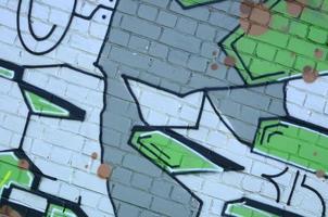 Fragment of graffiti drawings. The old wall decorated with paint stains in the style of street art culture. Colored background texture in green tones photo
