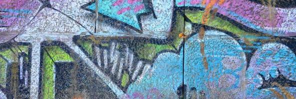 Fragment of graffiti drawings. The old wall decorated with paint stains in the style of street art culture. Colored background texture in purple tones photo