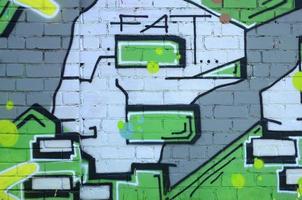 Fragment of graffiti drawings. The old wall decorated with paint stains in the style of street art culture. Colored background texture in green tones photo