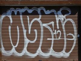 fragmento de un viejo dibujo de graffiti de color en la puerta del obturador. imagen de fondo como ilustración de arte callejero, vandalismo y pintura mural con pintura en aerosol foto