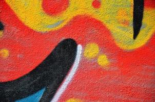 Fragment of an old colored graffiti drawing on the wall. Background image as an illustration of street art, vandalism and wall painting with aerosol paint photo