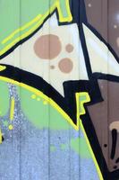 Fragment of graffiti drawings. The old wall decorated with paint stains in the style of street art culture. Colored background texture photo