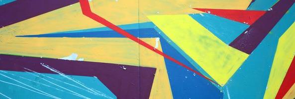 Fragment of graffiti drawings. The old wall decorated with paint stains in the style of street art culture. Colored background texture photo