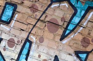 Fragment of graffiti drawings. The old wall decorated with paint stains in the style of street art culture. Colored background texture photo