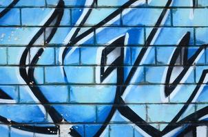 Fragment of graffiti drawings. The old wall decorated with paint stains in the style of street art culture. Colored background texture photo