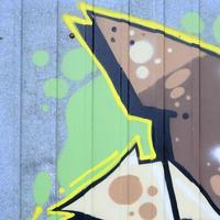 Fragment of graffiti drawings. The old wall decorated with paint stains in the style of street art culture. Colored background texture photo