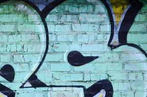 Fragment of graffiti drawings. The old wall decorated with paint stains in the style of street art culture. Colored background texture photo