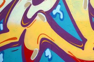 Fragment of graffiti drawings. The old wall decorated with paint stains in the style of street art culture. Colored background texture photo