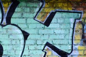 Fragment of graffiti drawings. The old wall decorated with paint stains in the style of street art culture. Colored background texture photo