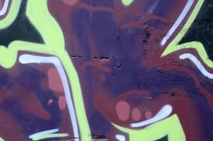 Fragment of graffiti drawings. The old wall decorated with paint stains in the style of street art culture. Colored background texture photo