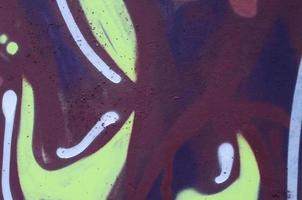 Fragment of graffiti drawings. The old wall decorated with paint stains in the style of street art culture. Colored background texture photo