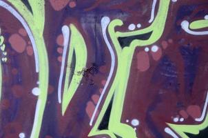 Fragment of graffiti drawings. The old wall decorated with paint stains in the style of street art culture. Colored background texture photo