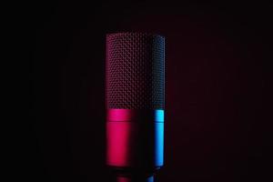 Studio microphone on dark background with neon lights photo