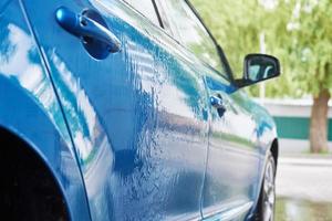 Cleaning car with high pressure water at car wash station photo