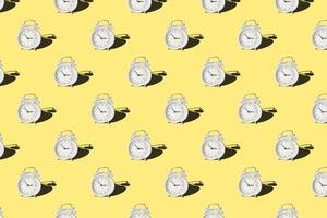 Seamless pattern with vintage alarm clock on yellow background photo