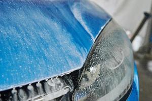 Cleaning car with high pressure water at car wash station photo