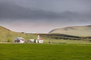 Small church in southern Iceland countryside under overcast sky