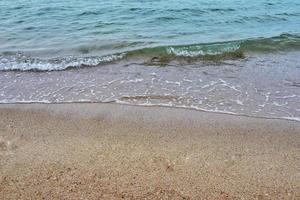 costa del mar y olas en movimiento en la playa de arena para fondo y texto inspirador. foto