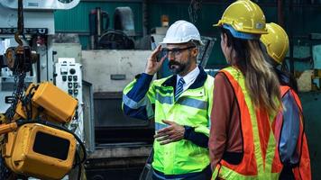 Mechanical engineer manager working in industry and factory control worker and introduce teamwork wearing safety reflective vest and  helmet to protection photo