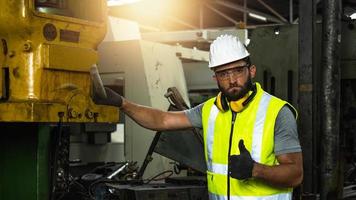Portrait of worker show thumb up, technical engineer check and fix machine in factory, mechanical man working concept photo