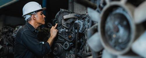 Attractive man working hard and fix Auto mechanic on car engine in mechanics garage. Repair service photo
