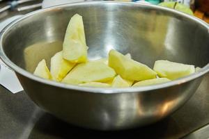 Sliced apples in bowl to make an apple pie. Step by step recipe photo
