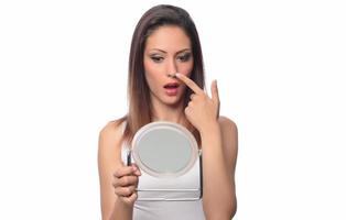 Beautiful woman sitting in front of a mirror. face of a healthy woman applying cream and makeup. Advertisement for skin cream, anti-wrinkle cream, baby face photo