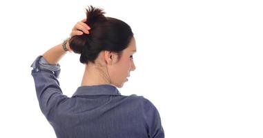 A woman makes a messy hair bun on her head photo