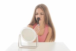 Beautiful woman sitting in front of a mirror. face of a healthy woman applying cream and makeup. Advertisement for skin cream, anti-wrinkle cream, baby face photo