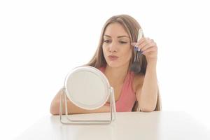 Beautiful woman sitting in front of a mirror. face of a healthy woman applying cream and makeup. Advertisement for skin cream, anti-wrinkle cream, baby face photo