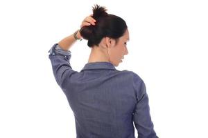 A woman makes a messy hair bun on her head photo