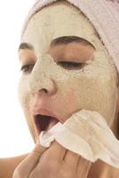 Beauty procedures skin care concept. Young woman applying facial mud clay mask to her face photo