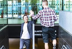 apuesto hombre de negocios asiático con traje y caminando al aire libre, gerente exitoso durante el descanso caminando por la ciudad. foto