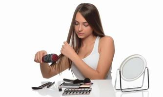 hermosa mujer joven mirarse en el cepillo de espejo cabello moreno largo y saludable foto