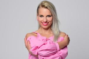 mujer sonriente rubia de moda con accesorios modernos posando en el estudio foto