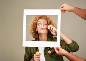 woman in picture frame blowing bubbles photo