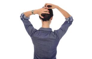 A woman makes a messy hair bun on her head photo