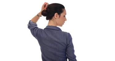 A woman makes a messy hair bun on her head photo