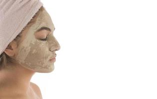 Beauty procedures skin care concept. Young woman applying facial mud clay mask to her face photo