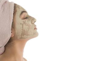 Beauty procedures skin care concept. Young woman applying facial mud clay mask to her face photo