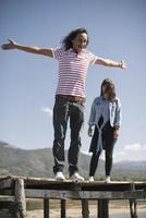 love couple resting on pier, man pointing at lake photo