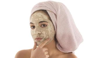 Beauty procedures skin care concept. Young woman applying facial mud clay mask to her face photo