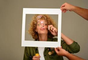 woman in picture frame blowing bubbles photo