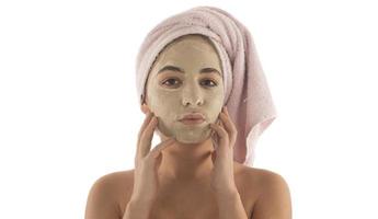 Beauty procedures skin care concept. Young woman applying facial mud clay mask to her face photo